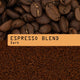 Dark espresso blend coffee shown with whole roasted coffee beans at the top,  ground coffee below, and an peach label across the center reading 'ESPRESSO BLEND, Dark'.