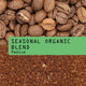 A close-up product photo for a coffee blend showing roasted coffee beans at the top, a green label reading 'SEASONAL ORGANIC BLEND Medium' across the center, and ground coffee at the bottom.