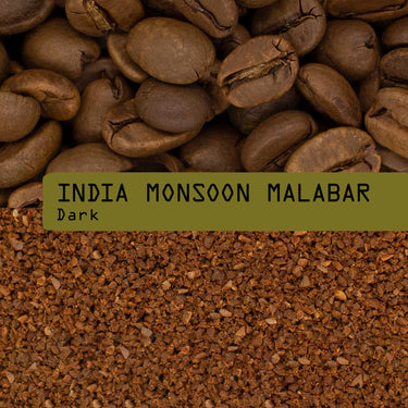 Coffee bean whole and ground close-up with a green label reading 'INDIA MONSOON MALABAR Dark'.